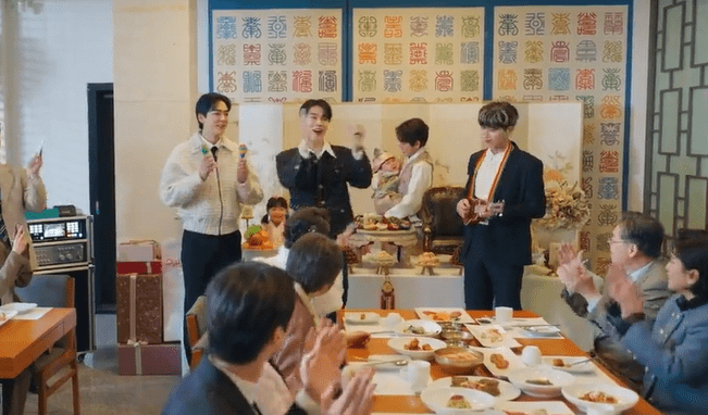 Grupo musical actuando en una celebración con comida en la mesa y decoraciones coloridas en el fondo