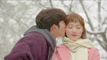 Pareja compartiendo un tierno beso en la nieve durante el episodio 2.