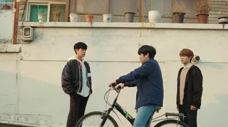 Tres jóvenes están cerca de una bicicleta uno de ellos la monta Episodio 01