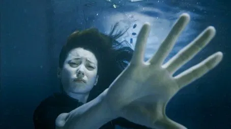 Mujer sumergida bajo el agua extendiendo la mano Episodio 01