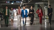 Un grupo elegante camina con confianza por un edificio moderno.