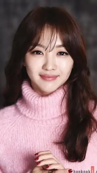 Foto de rostro de Jang Hee-jin, actriz surcoreana, vistiendo un suéter rosa.