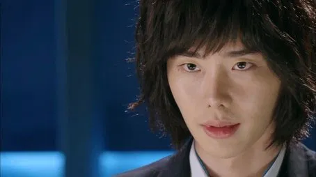 Retrato en primer plano de un joven con cabello oscuro y desgreñado.