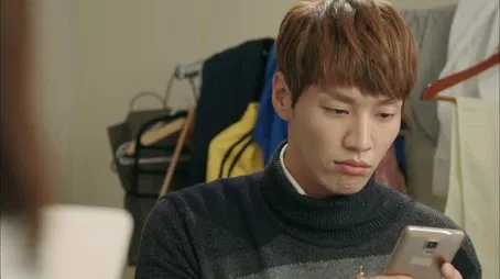 Hombre mirando un teléfono inteligente, expresión pensativa