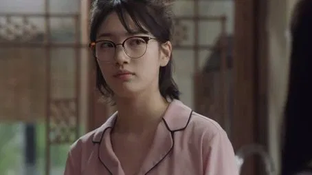 Mujer joven con gafas y pijama rosa