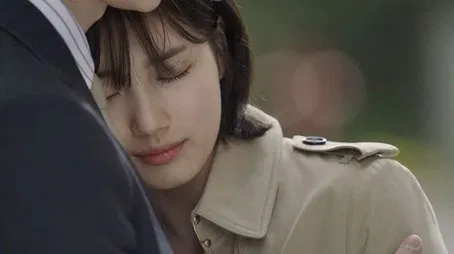 Mujer abrazando a hombre, ojos cerrados, mostrando tristeza o consuelo.