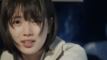 Primer plano de una mujer joven con cabello corto, que parece preocupada o intranquila.