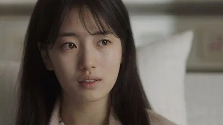 Primer plano de una mujer joven con cabello oscuro, que parece pensativa.