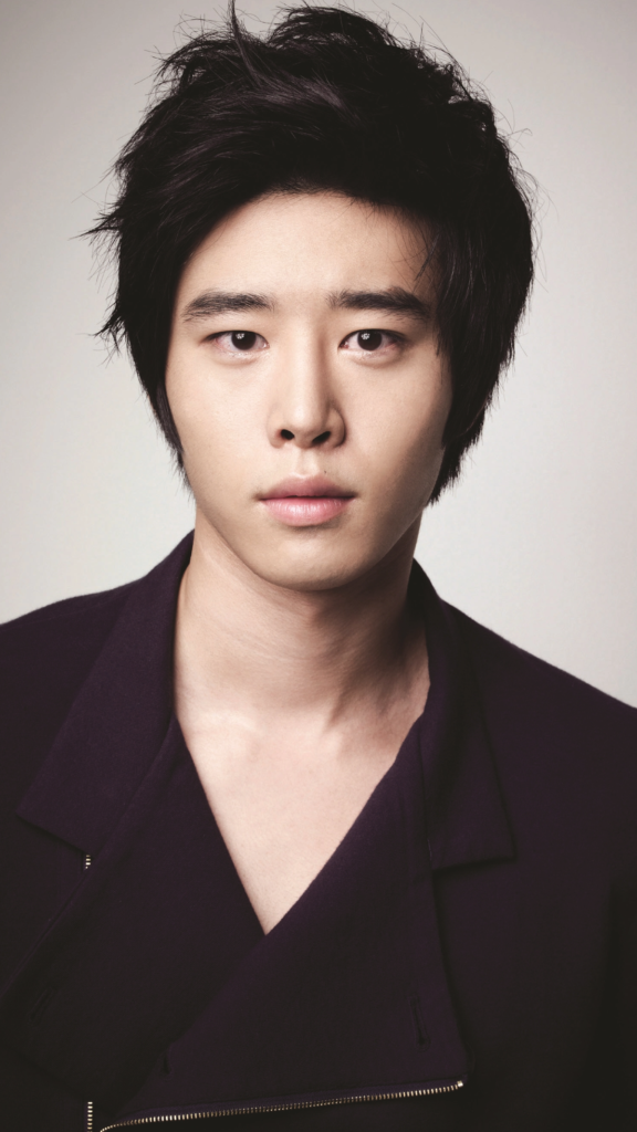 Retrato de Kim Kwon, actor asiático, con expresión seria y chaqueta oscura.